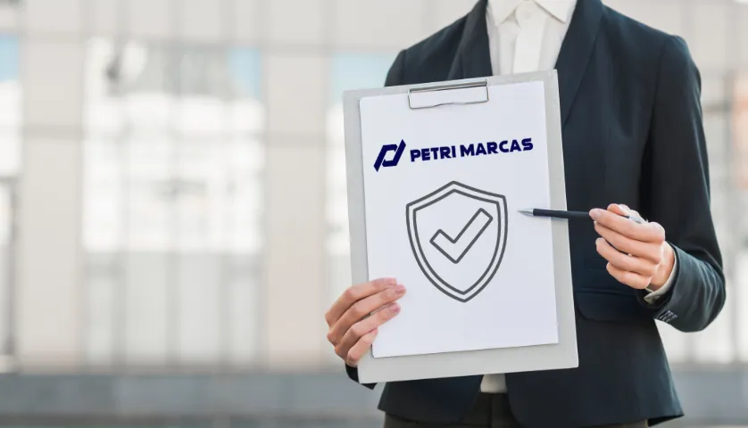 Profissional segurando uma prancheta com o selo da Petri Marcas e um escudo de proteção
